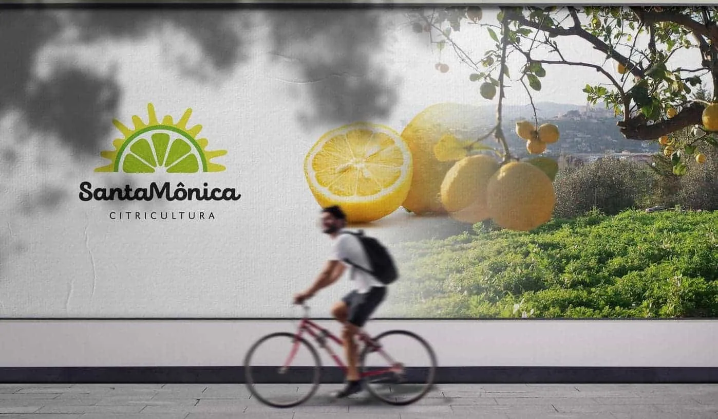 Marca Santa Mônica Citricultura num muro, com um ciclista passando
